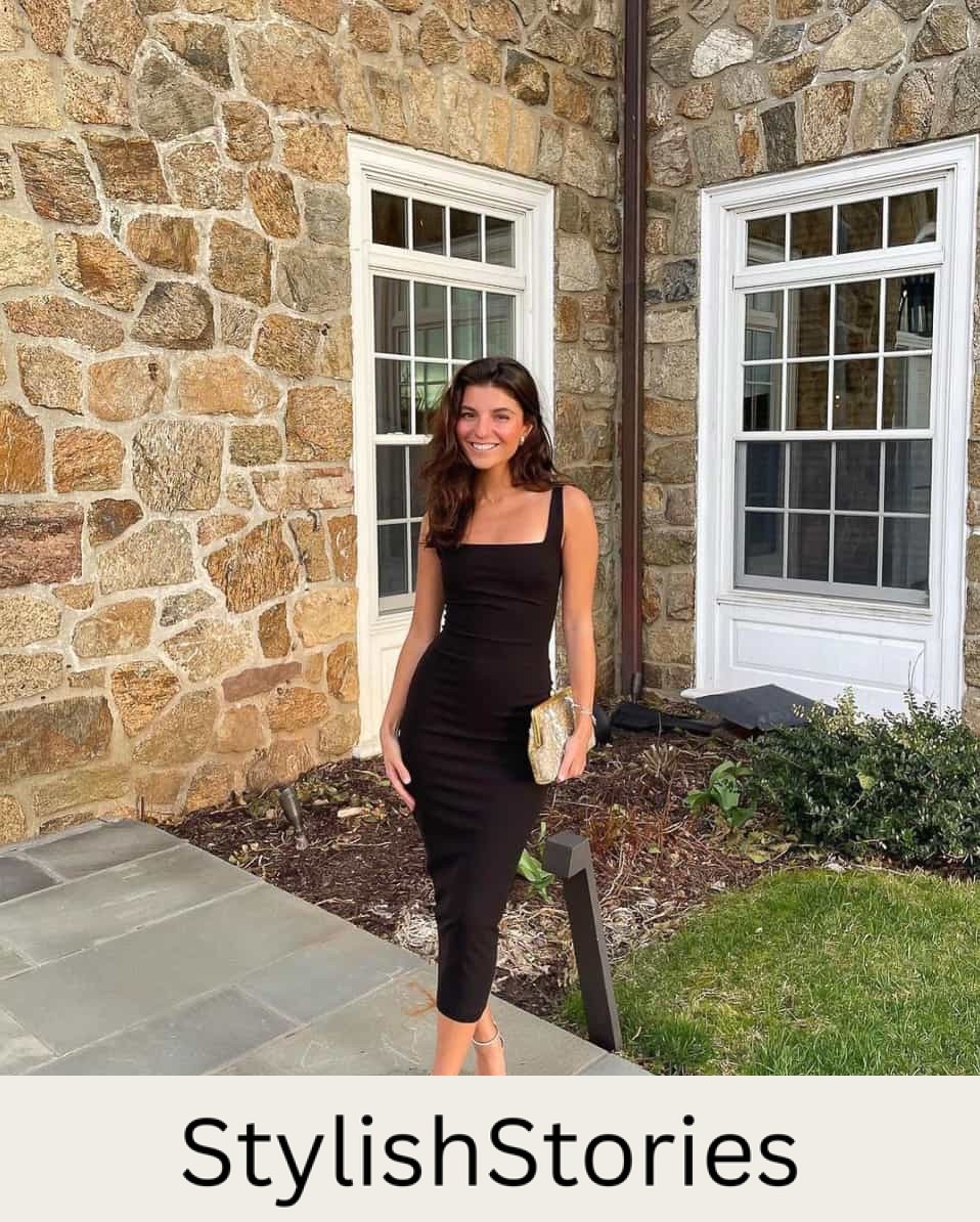 woman at a winery wearing a black midi dress with metallic heels