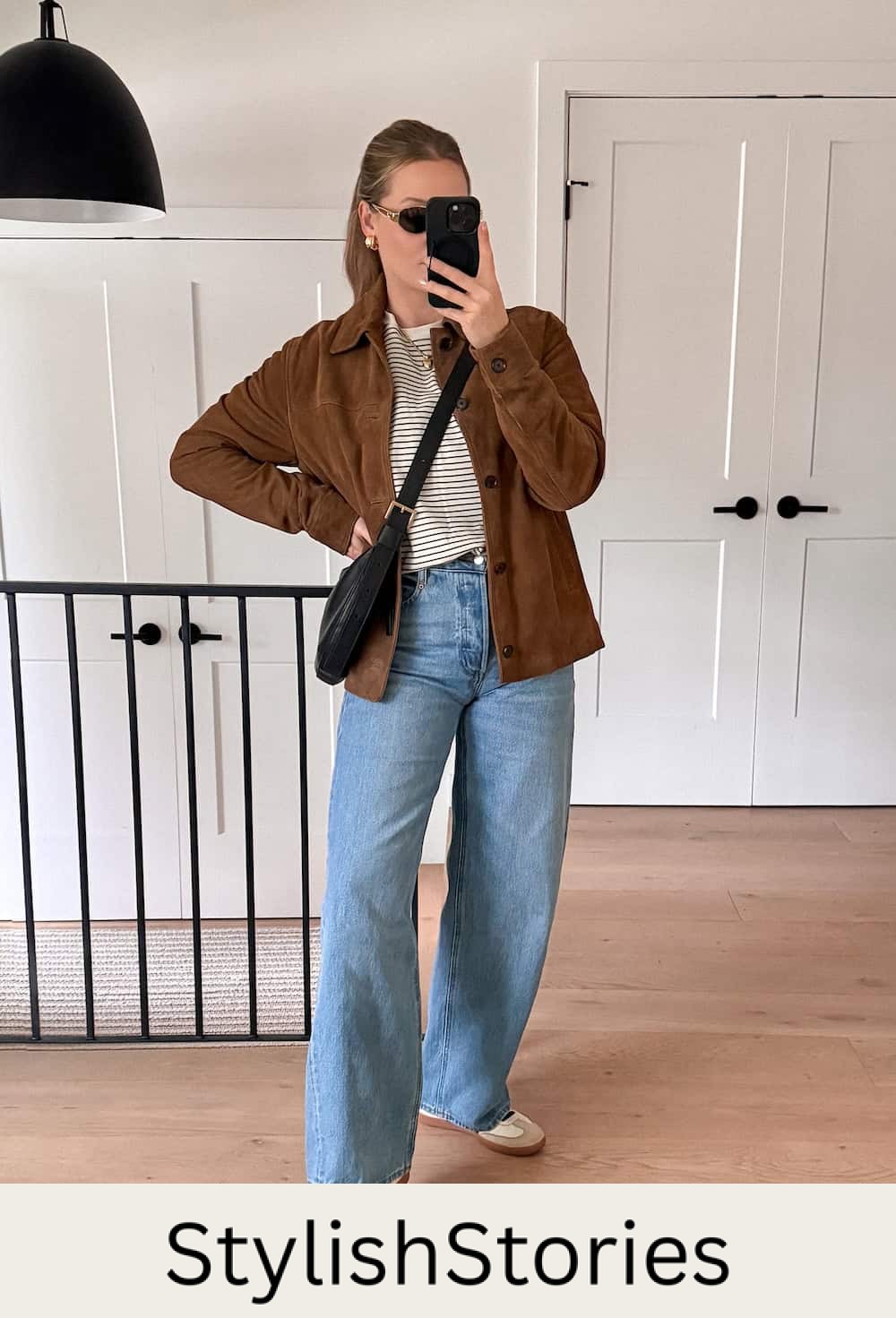 Christal wearing light wash wide leg jeans with a striped shirt and suede jacket.