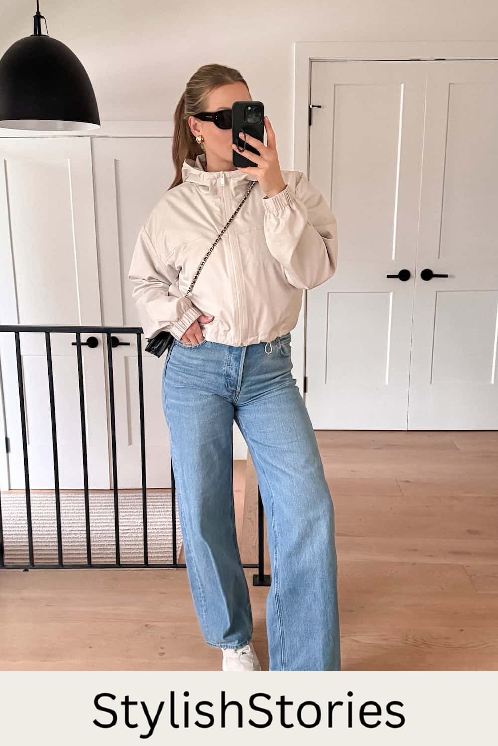 Christal wearing light wash wide leg jeans with a jacket and sneakers.