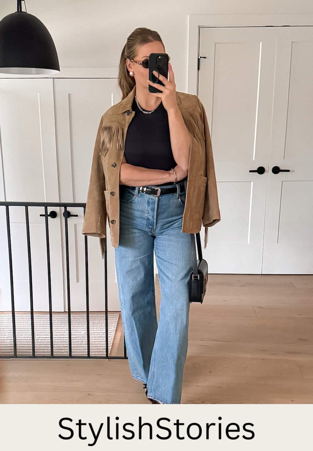 Christal wearing wide leg jeans with a black t-shirt and a suede jacket.