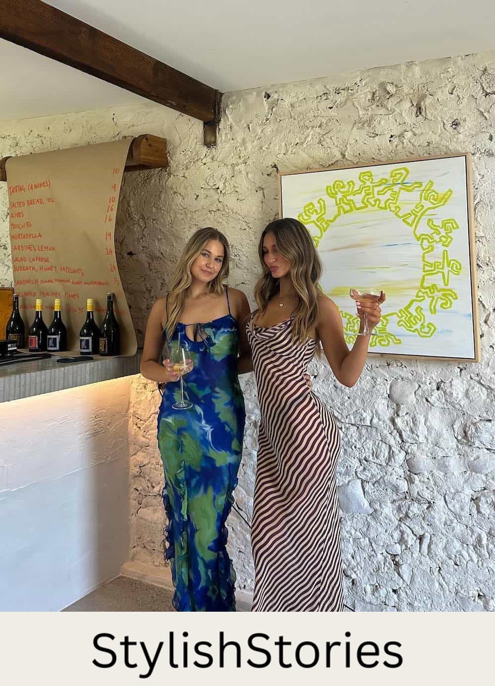 two women at a winery wearing printed maxi slip dresses