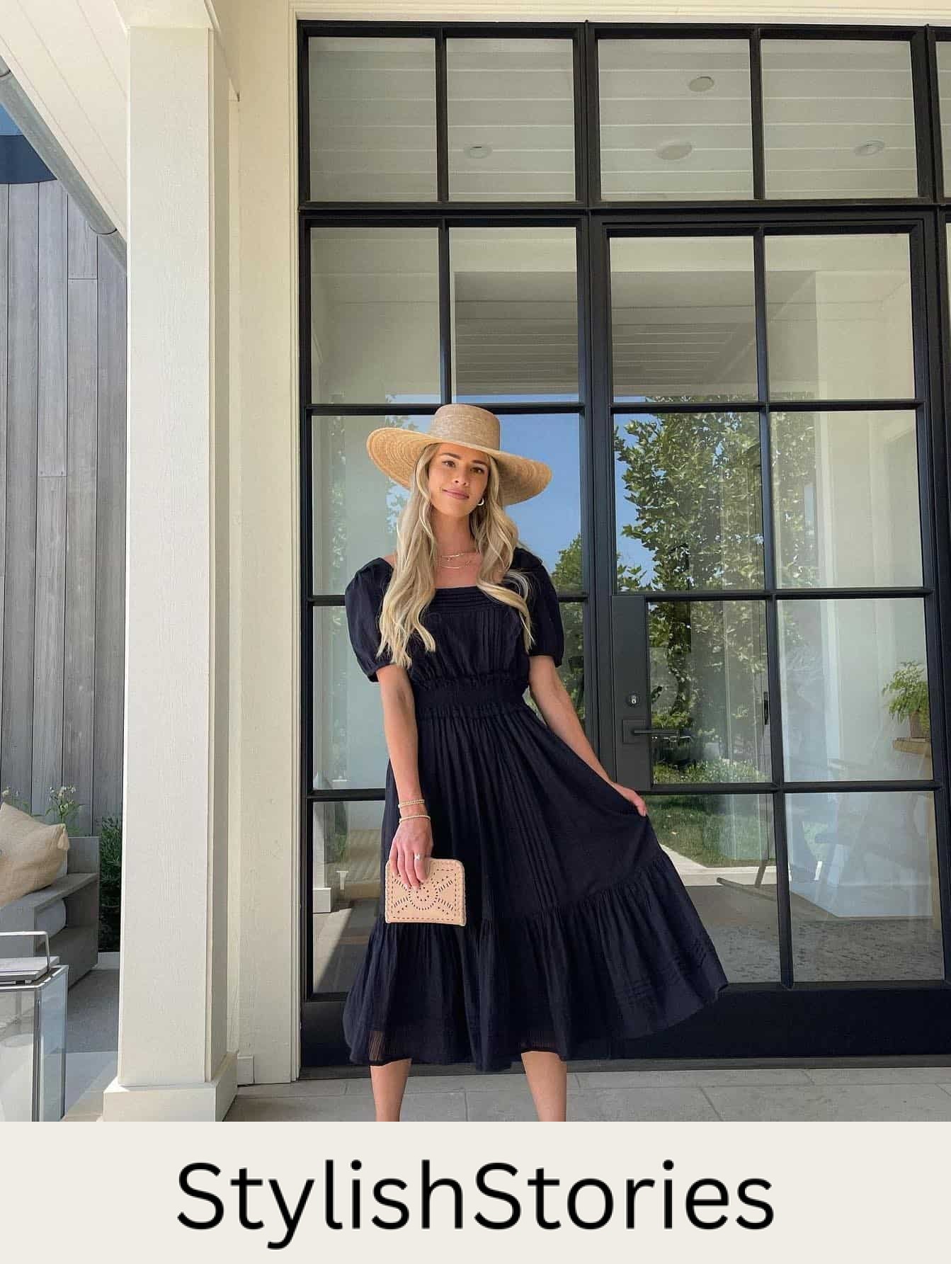 woman wearing a black midi dress with a straw hat and sandals as a chic winery outfit