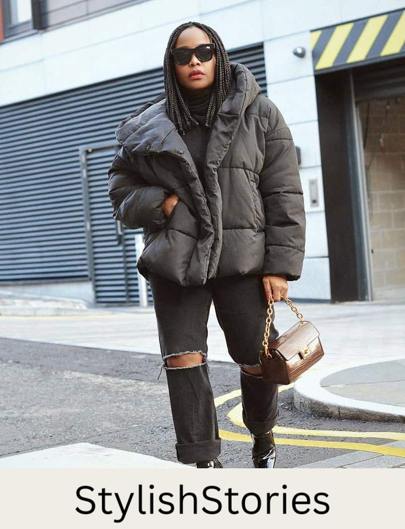 black woman wearing a black puffer coat with ripped jeans and leather boots