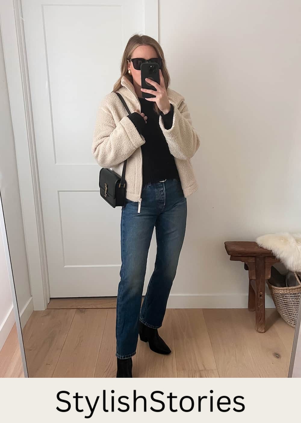 Christal wearing dark denim straight jeans with black booties and a white sherpa jacket.