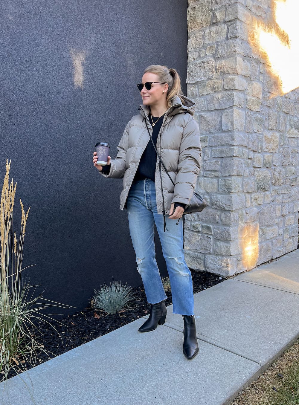 Christal wearing jeans with black booties a black sweater and a puffer coat.