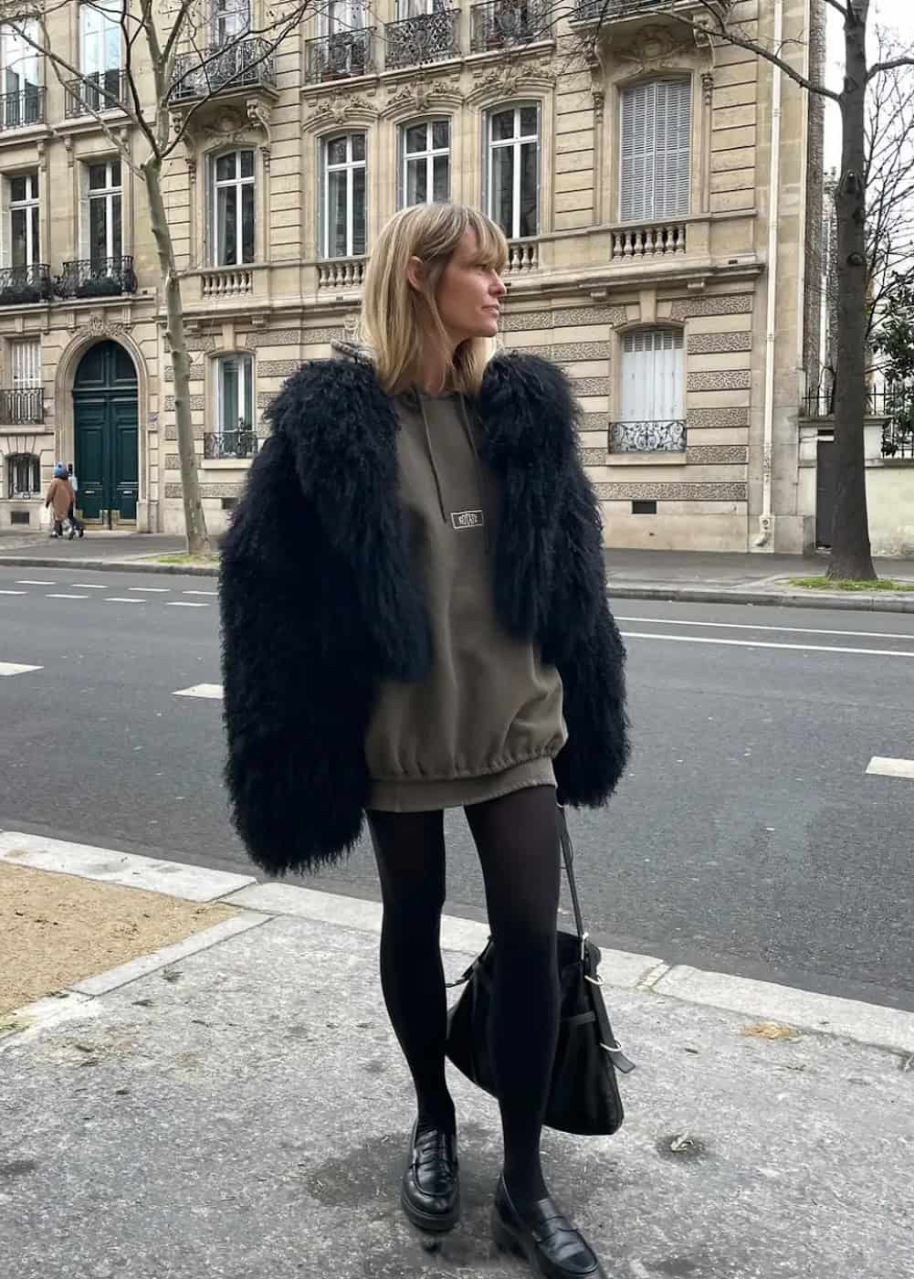 Woman wearing leggings and a faux fur coat.