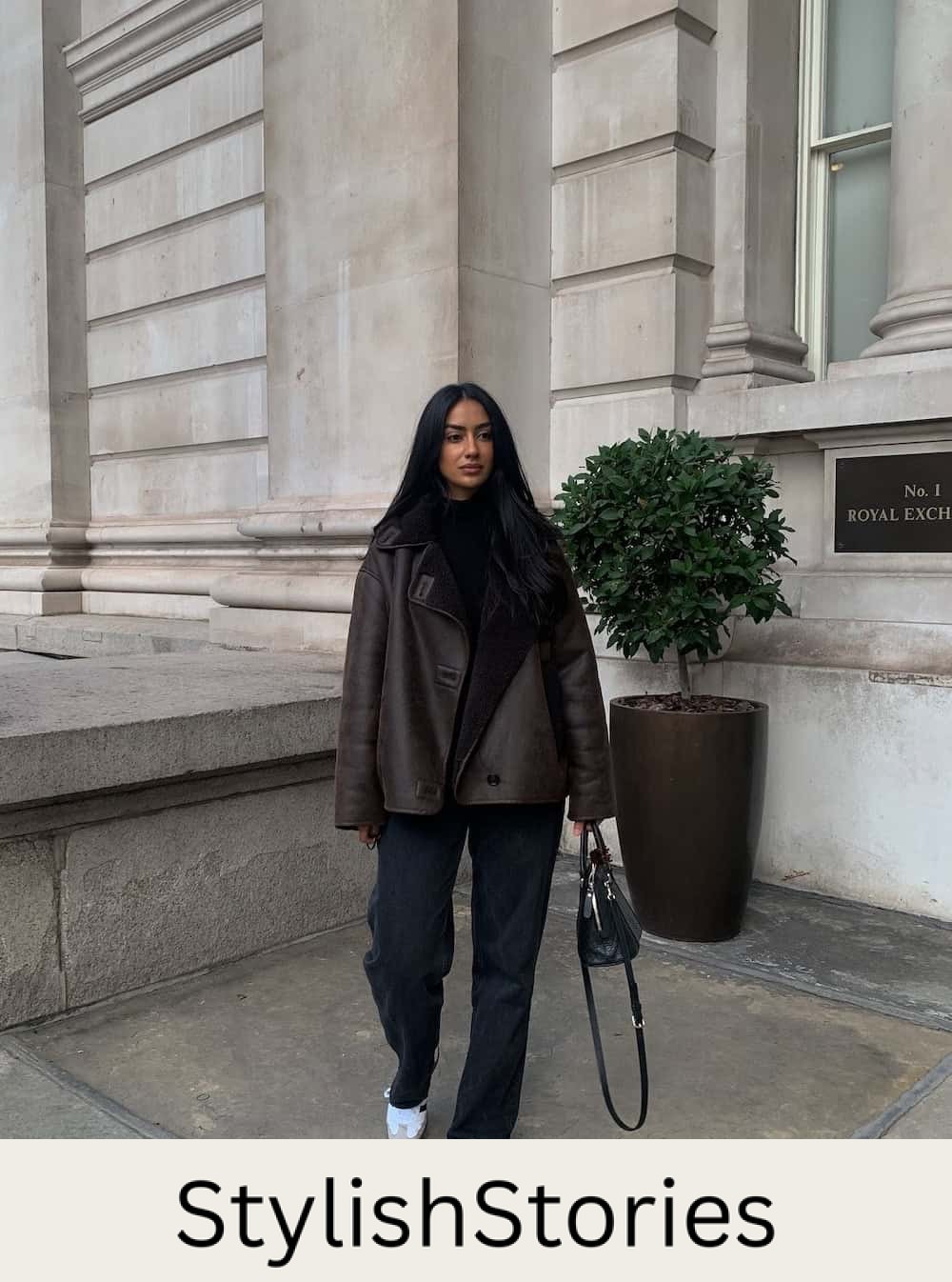 Woman wearing jeans, and an oversized coat with sambas.