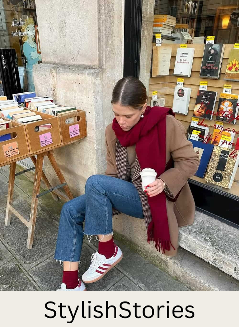 Woman wearing jeans, a blazer and a brown coat with a burgundy scarf and sambas.