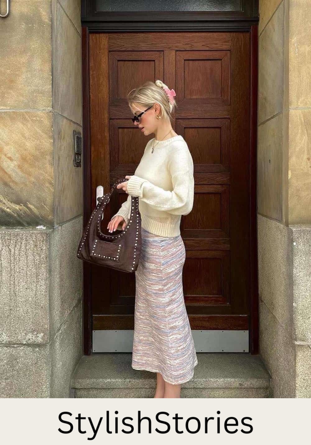 Woman wearing a yellow sweater with a long skirt and heeled sandals.