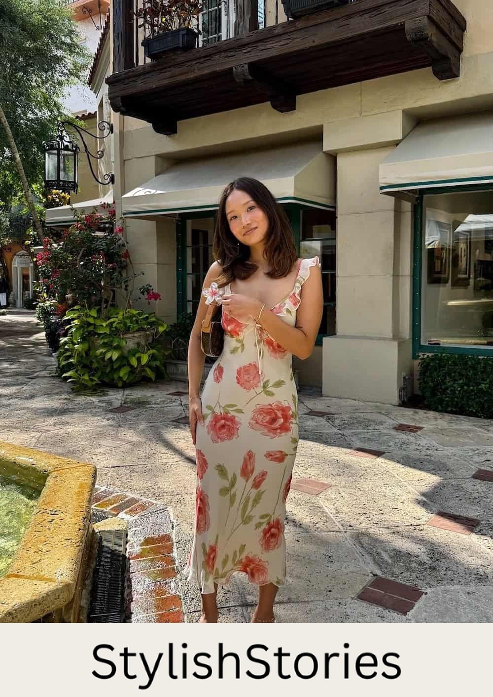 Woman wearing a floral print midi dress with heeled sandals.