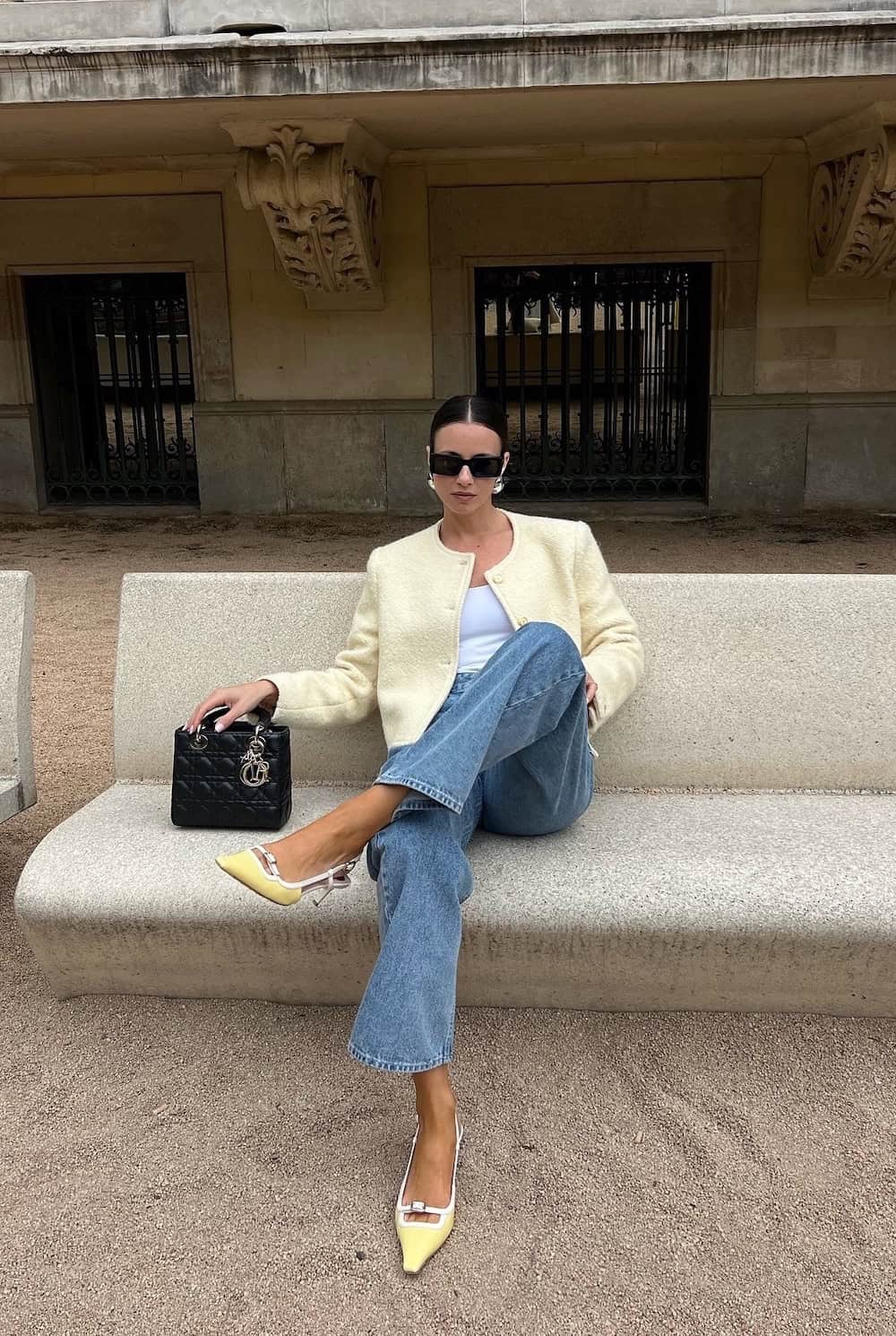 Woman wearing jeans with a white tank and a yellow jacket with yellow pumps.