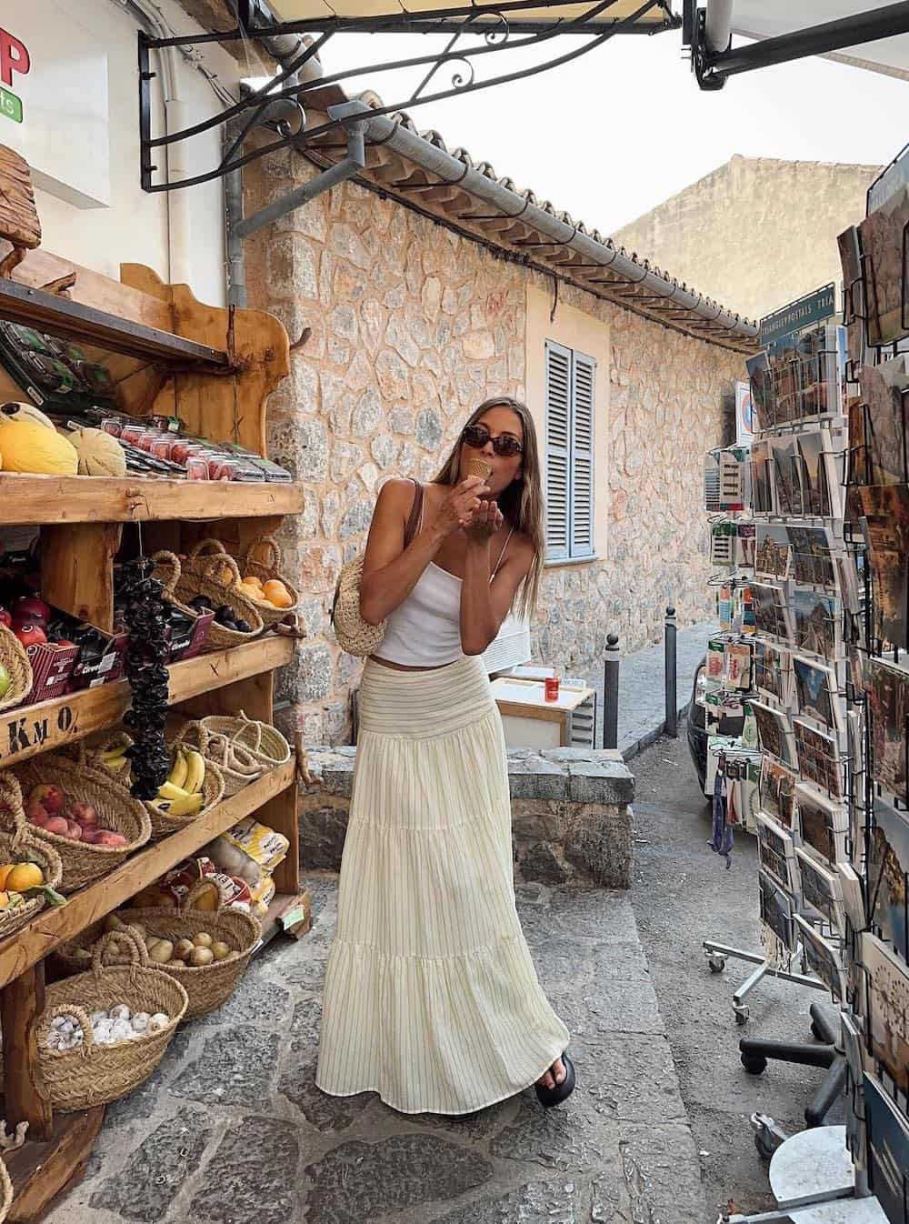 Woman wearing a linen maxi skirt with a white tank.