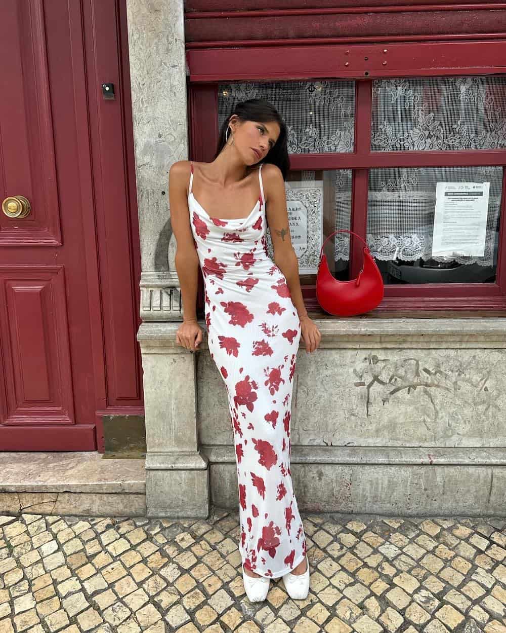 Woman wearing a white floral maxi dress with flats.