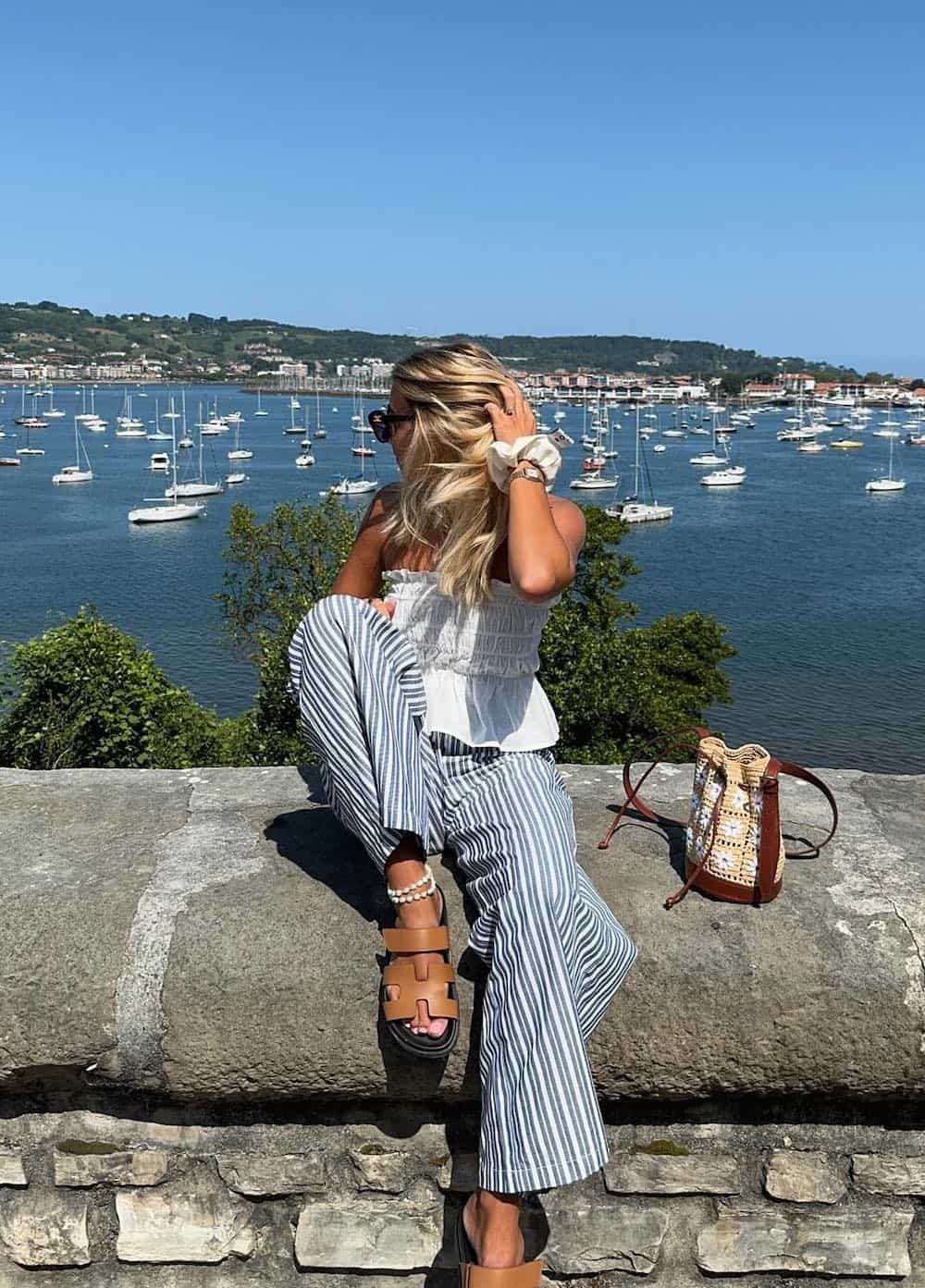 Woman wearing white and blue striped pants with a poplin strapless top.