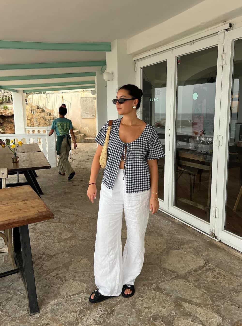 Woman wearing white linen pants with a black and white gingham top.