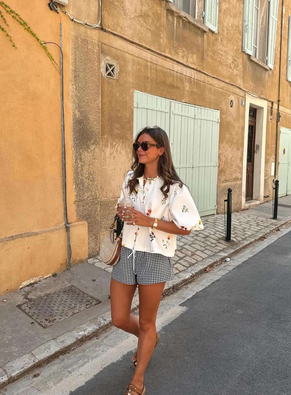 Woman wearing black and white gngham shirts with a floral print top.