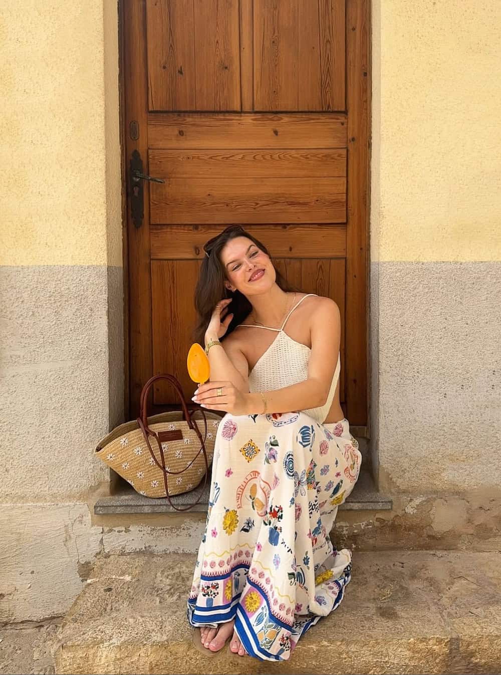 Woman wearing a printed maxi skirt with a halter-neck, crotchet top.