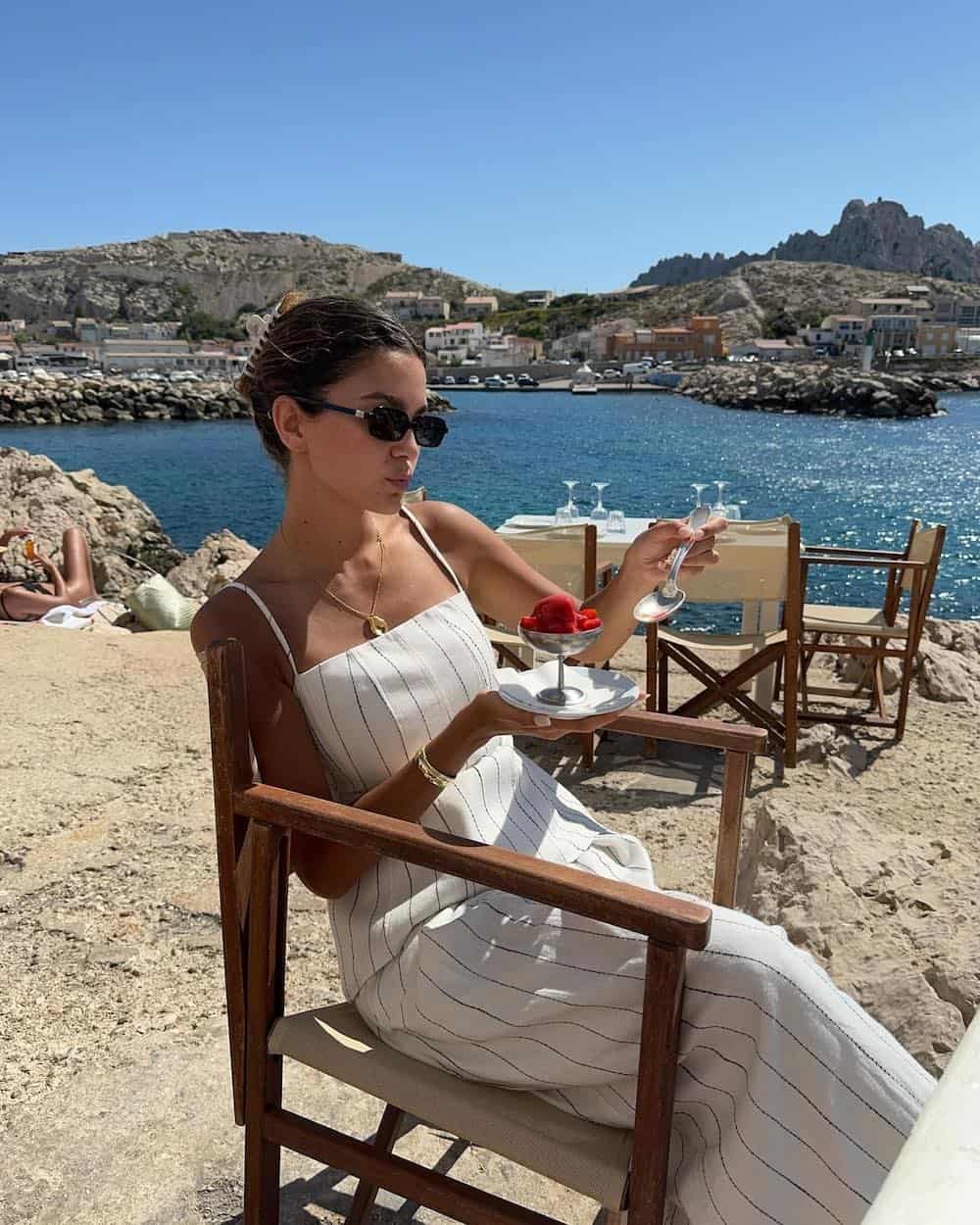 Woman wearing a white and black pinstripe cotton maxi dress.