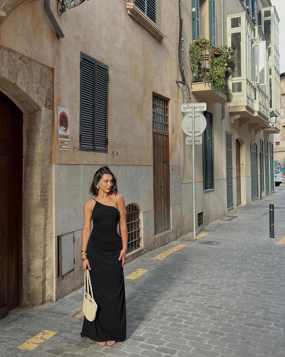 Woman wearing a black, one-shoulder maxi dress.