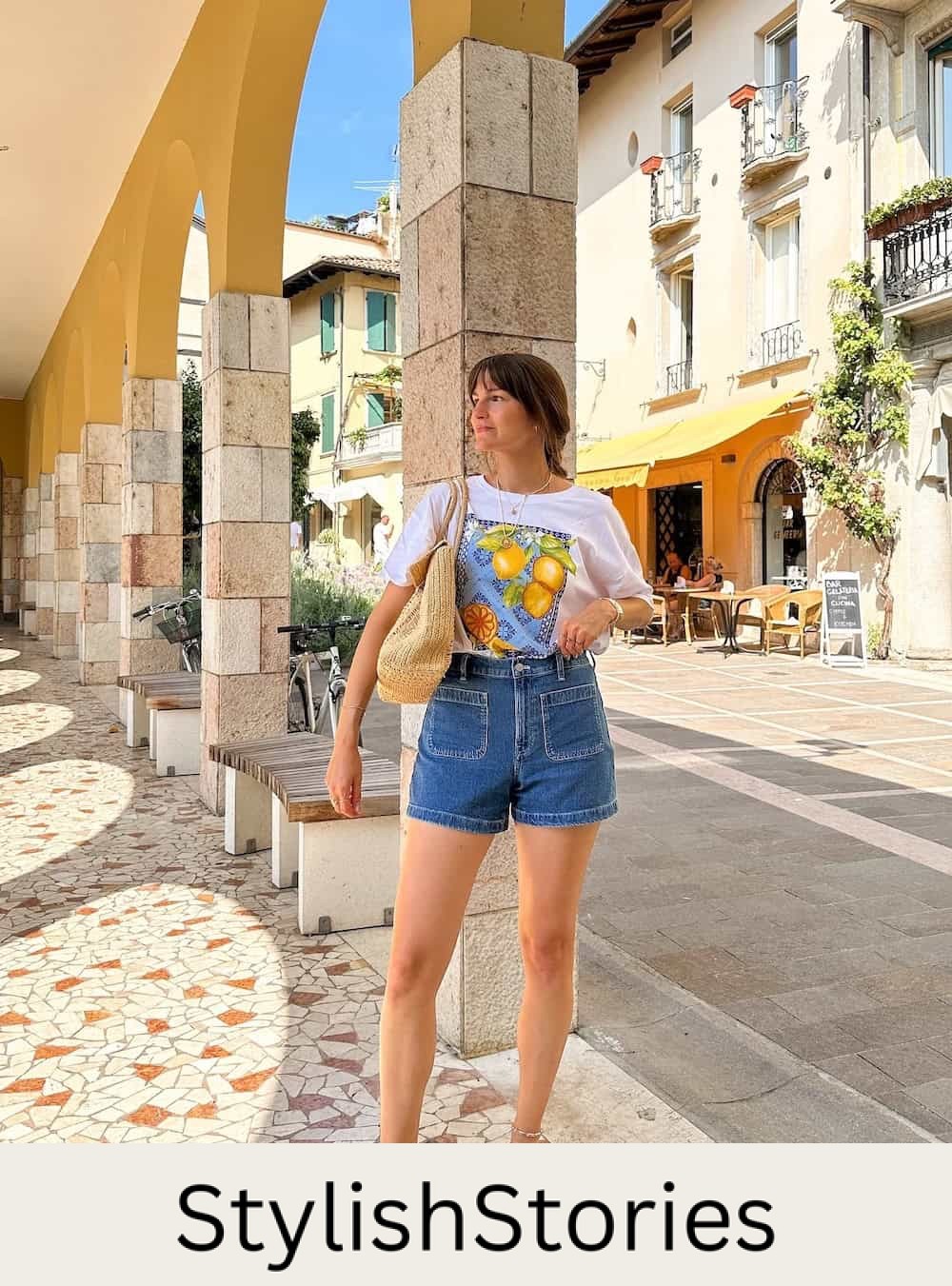 a woman wearing blue denim shorts with a summer tee and strappy brown sandals