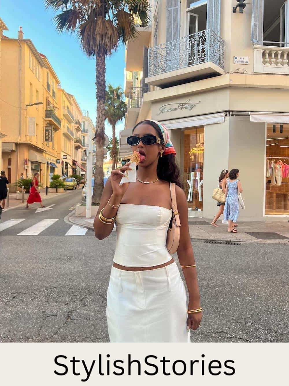 a woman wearing a white tube top and a white midi skirt