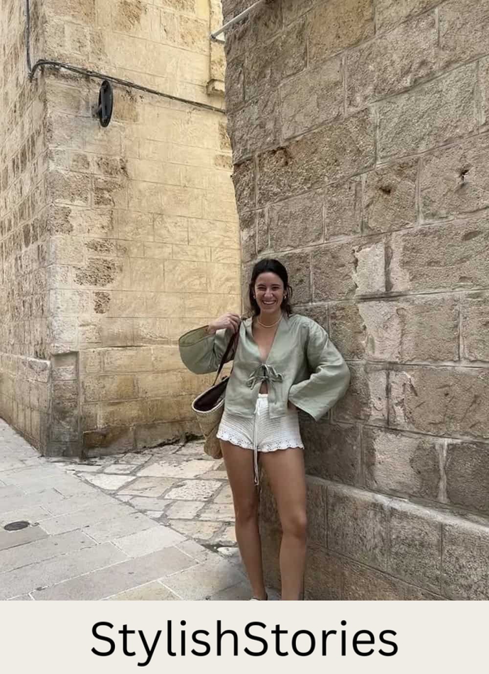 a woman wearing crochet white shorts with a green tie front top and white flats