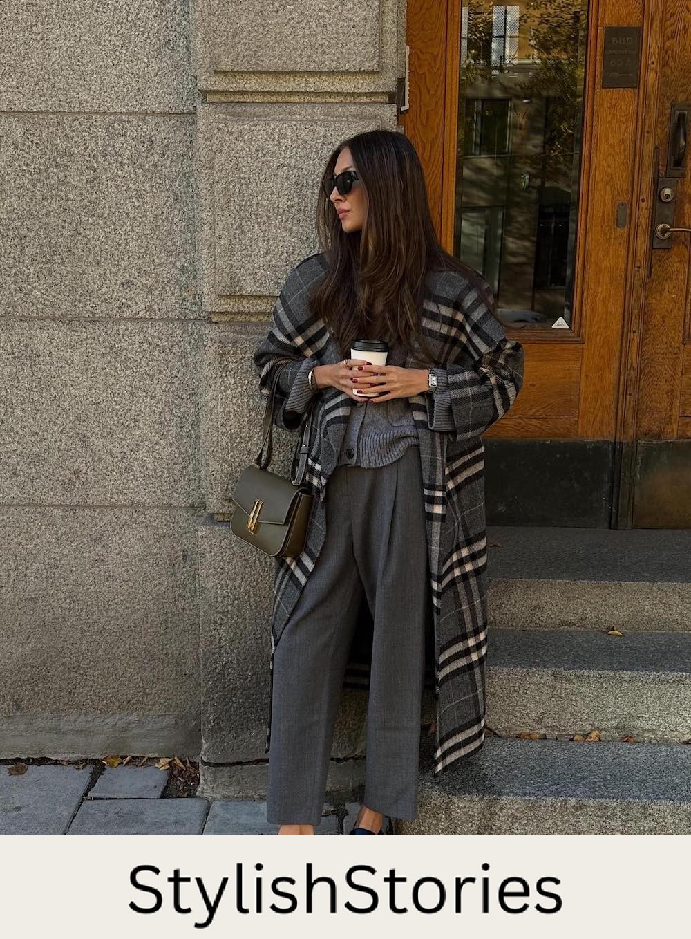 Woman wearing trousers and a cardigan with a long plaid coat.