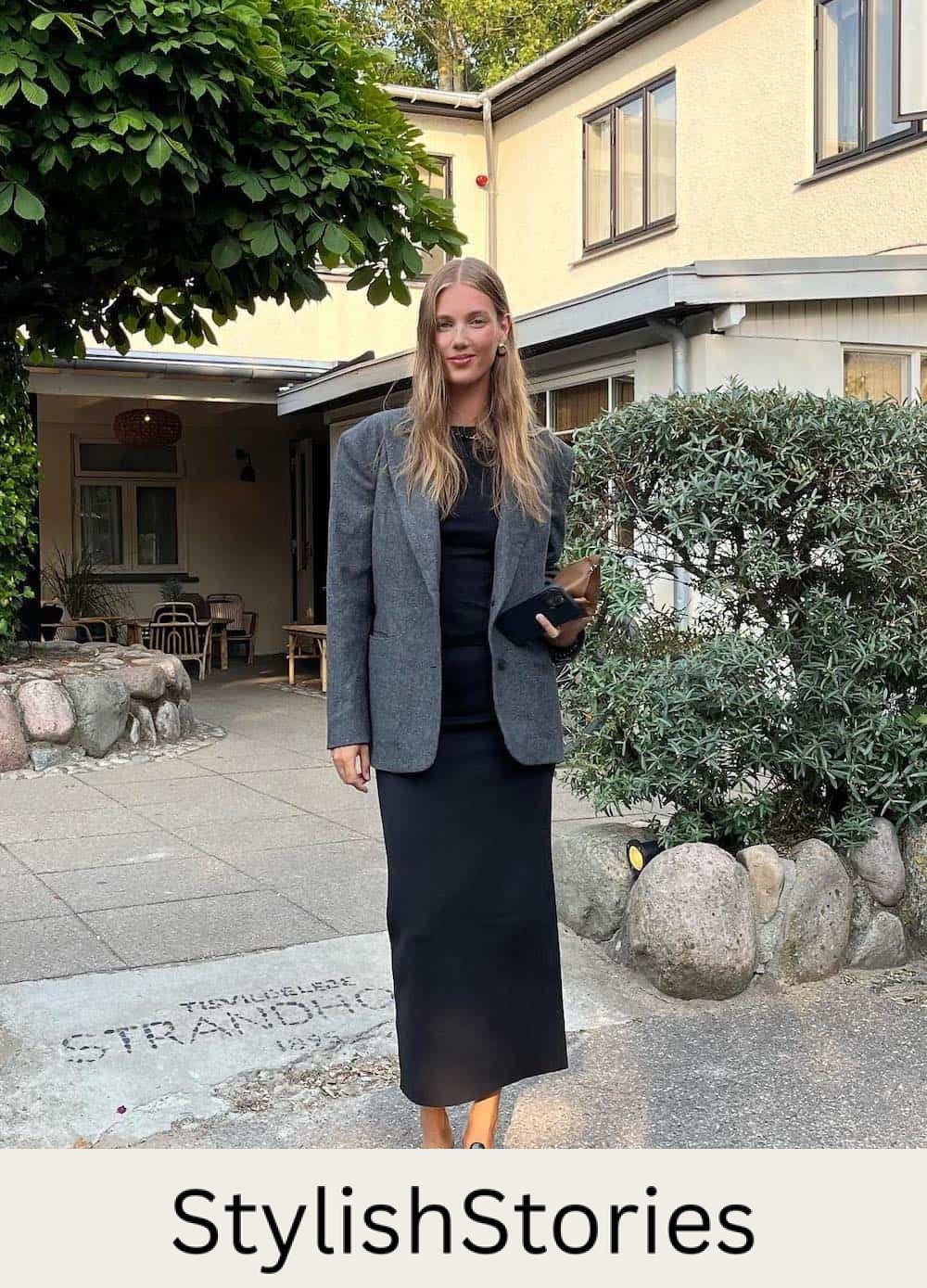 Woman wearing a black maxi skirt with a blazer and heels.