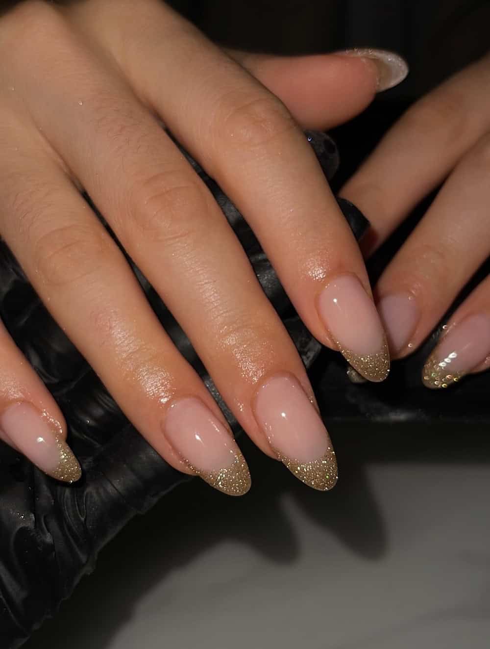 long nude almond nails with gold glitter tips