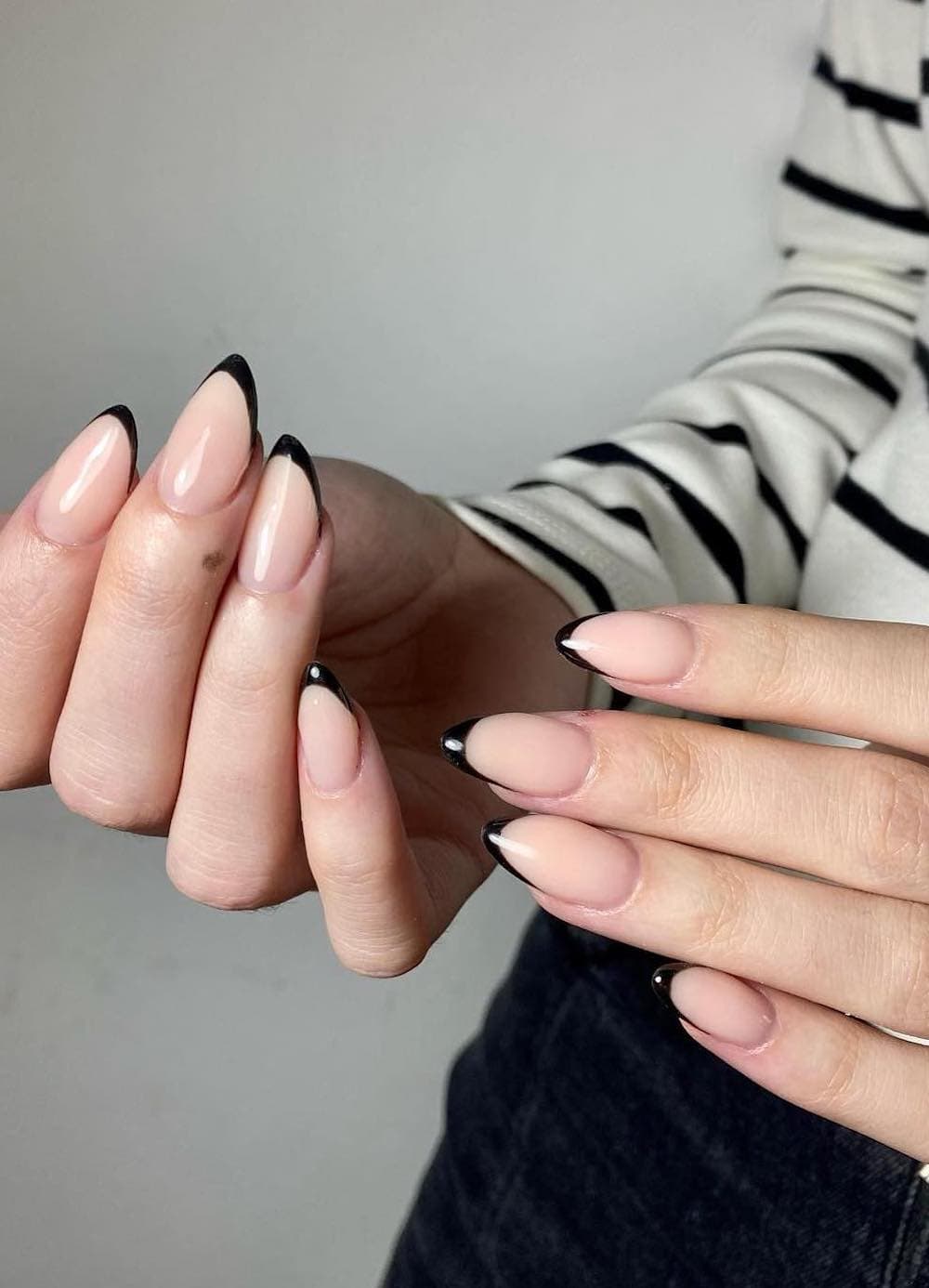 short nude almond nails with thin black tips
