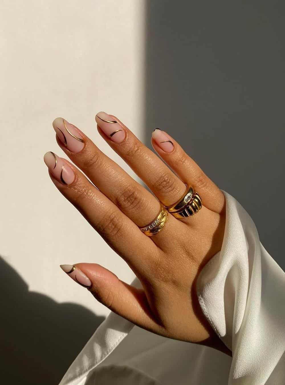 short nude nails with matte finish and gold accent lines