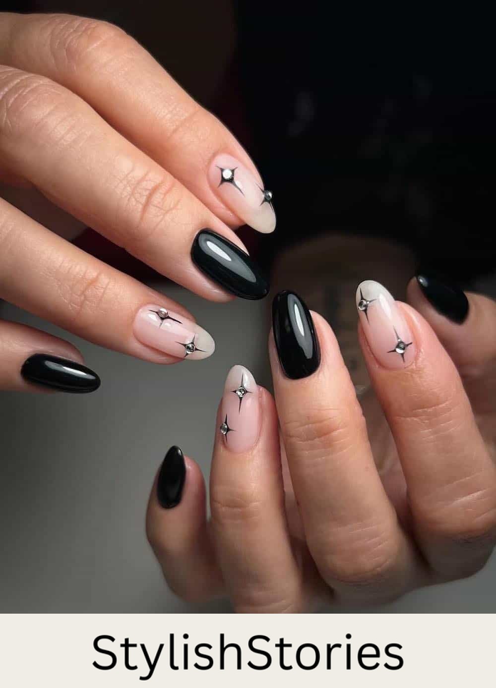 black nails with nude accent nails featuring gem stars