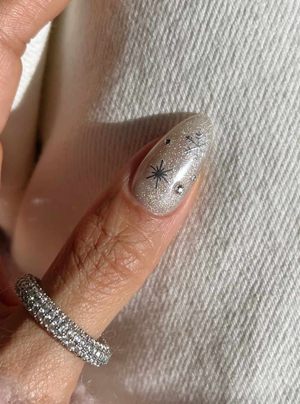 white glittering almond nails with silver snowflakes and gems