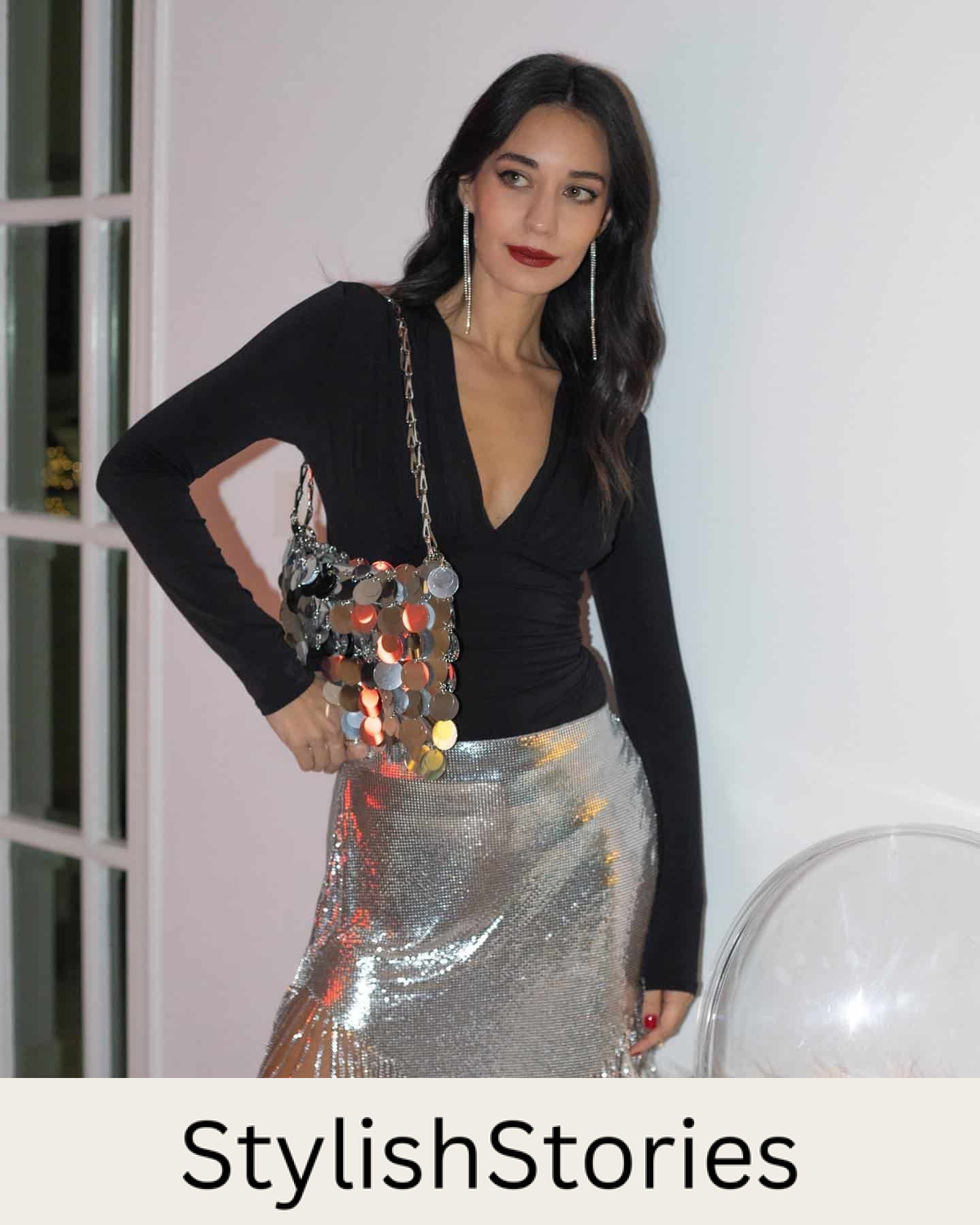 Woman wearing an asymmetrical sequined fringe skirt with a black top.