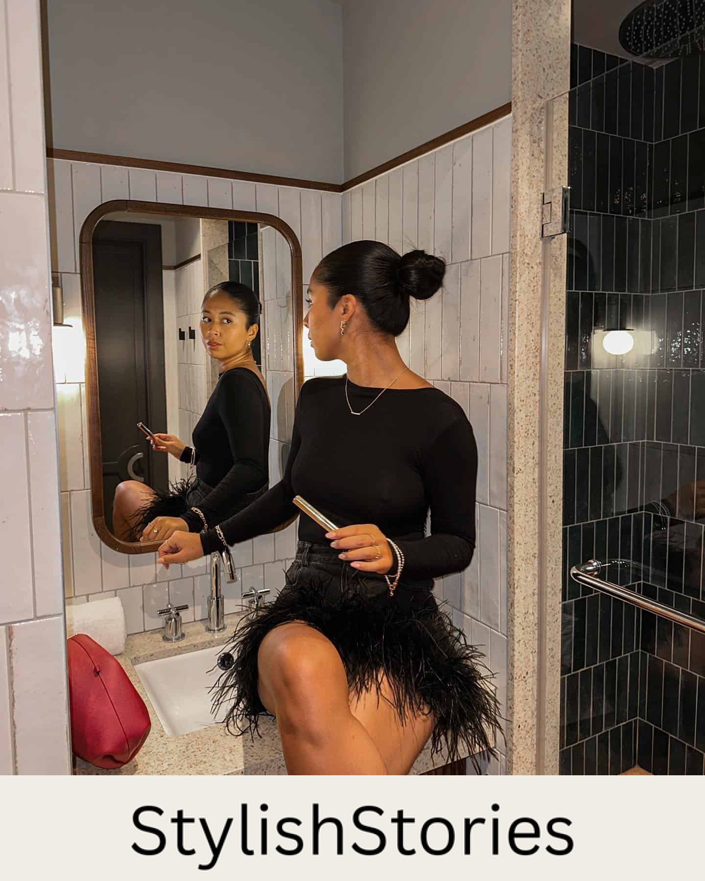 Woman wearing a black feather mini skirt with a black long sleeve top.