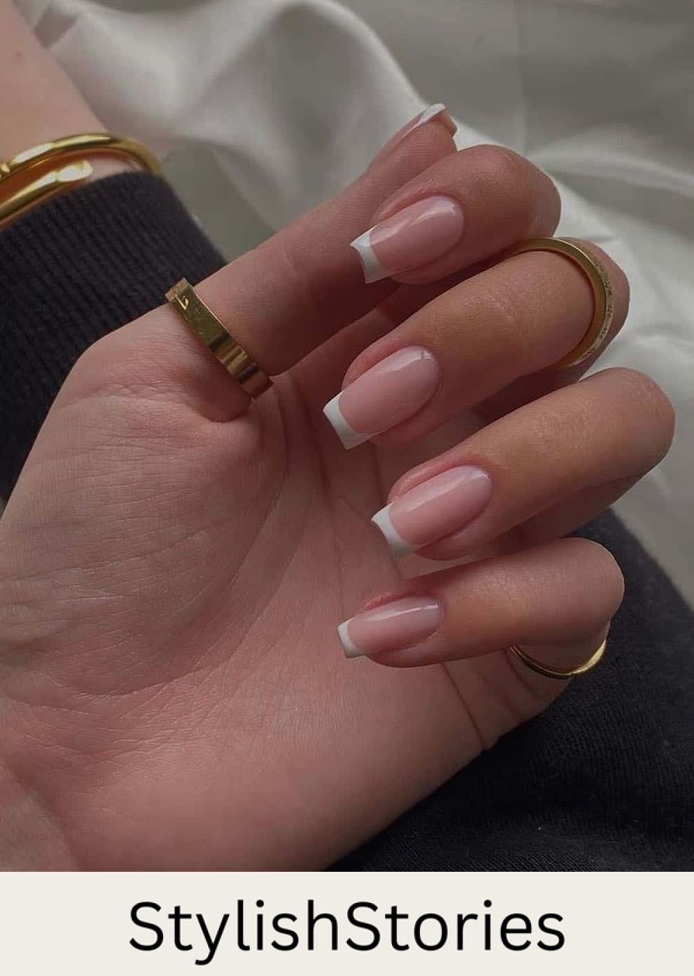 a hand with a long square french manicure
