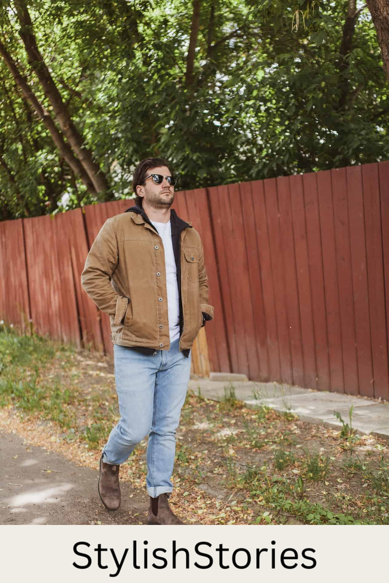 image of a man walking down an alley wearing a brown jacket, light blue jeans, and brown boots