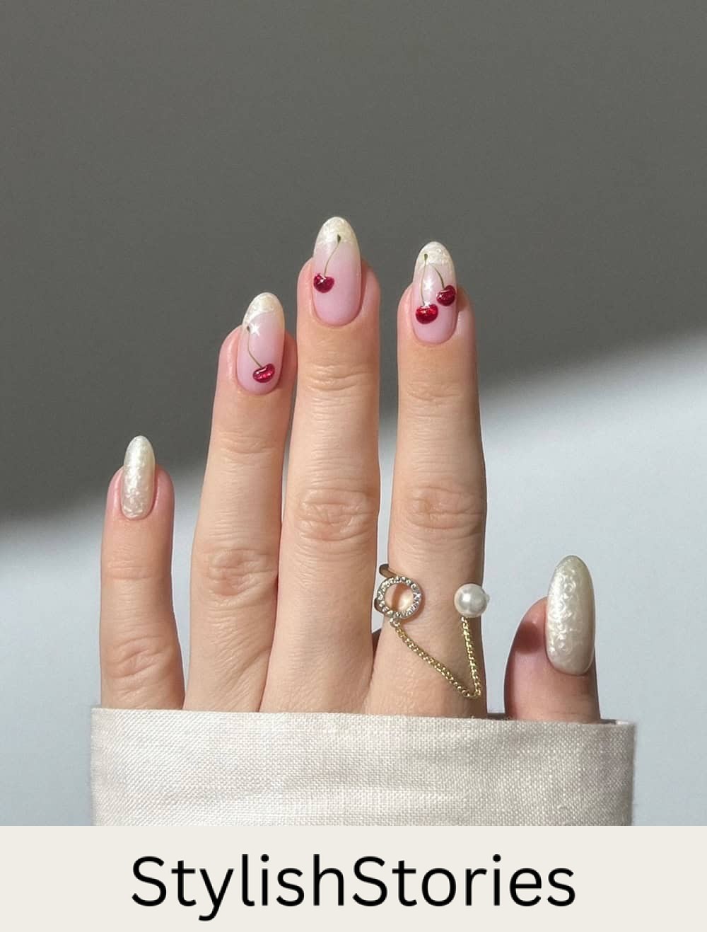 long nude nails with pearly white tips and cherry nail art