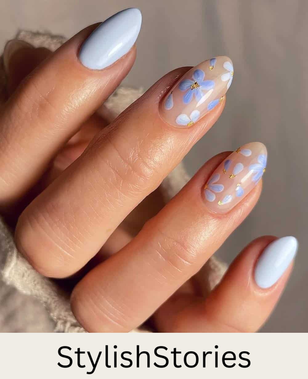 short almond nails with light blue polish and nude accent nails with blue flowers