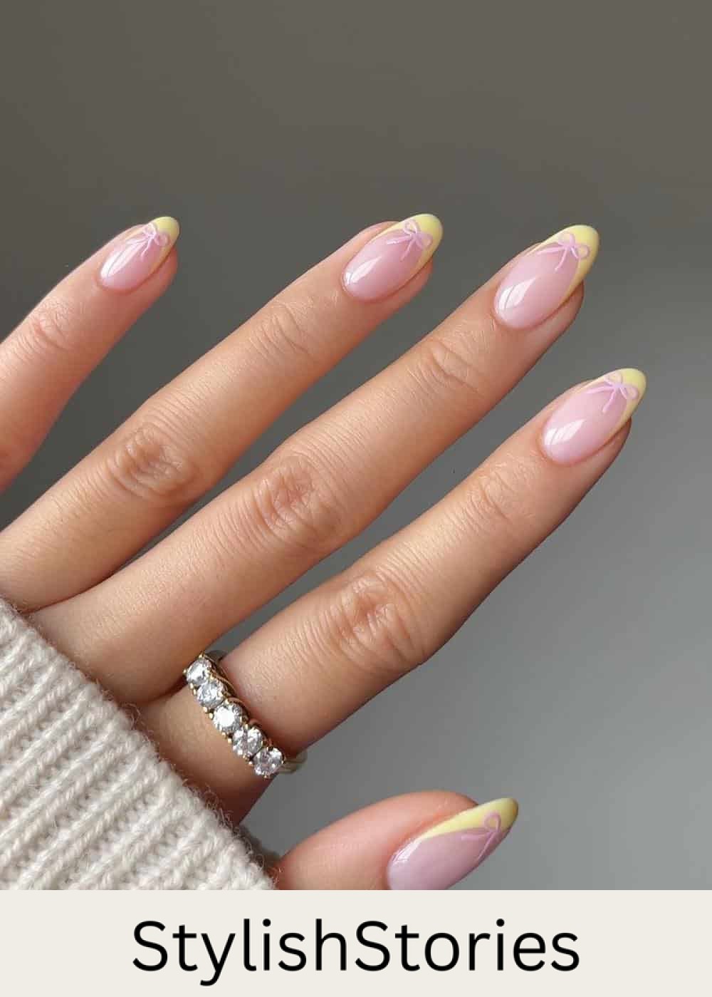 nude almond nails with yellow tips and pink bows