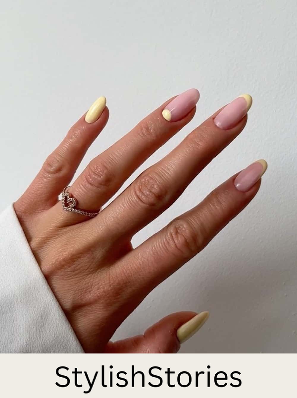 medium nude nails with yellow polish, tips, and reverse french tips