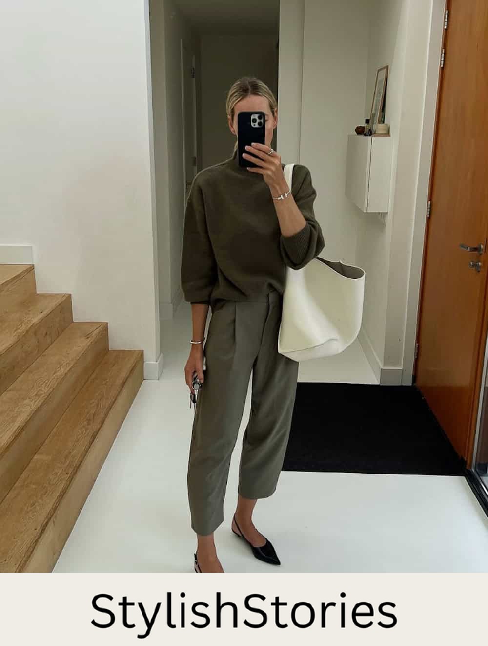 Woman wearing trousers with a mock neck sweater and pointed toe flats.