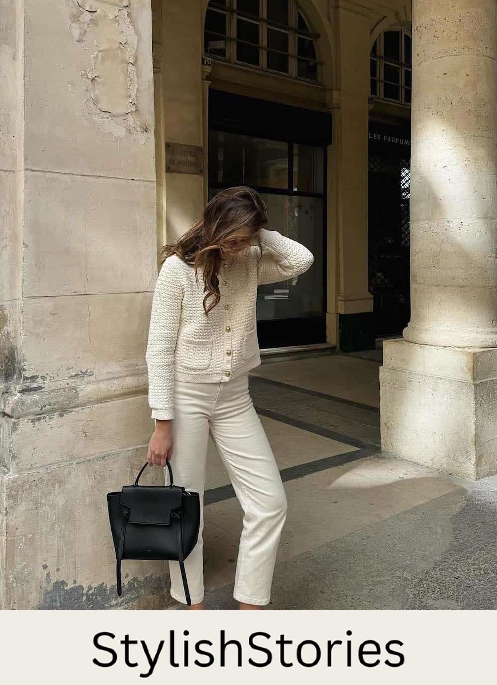 Woman wearing white jeans with a white jacket and black ballet flats.