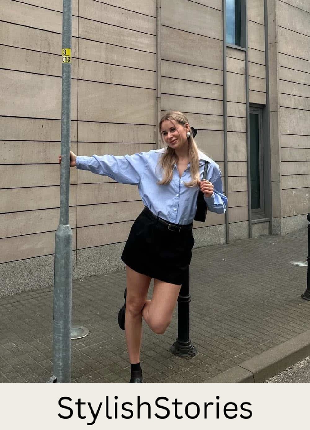 Woman wearing a black skirt with a blue button down.