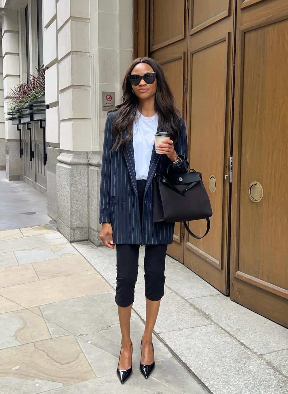 Woman wearing capris, a blazer, a white tee and pointed toe heels.