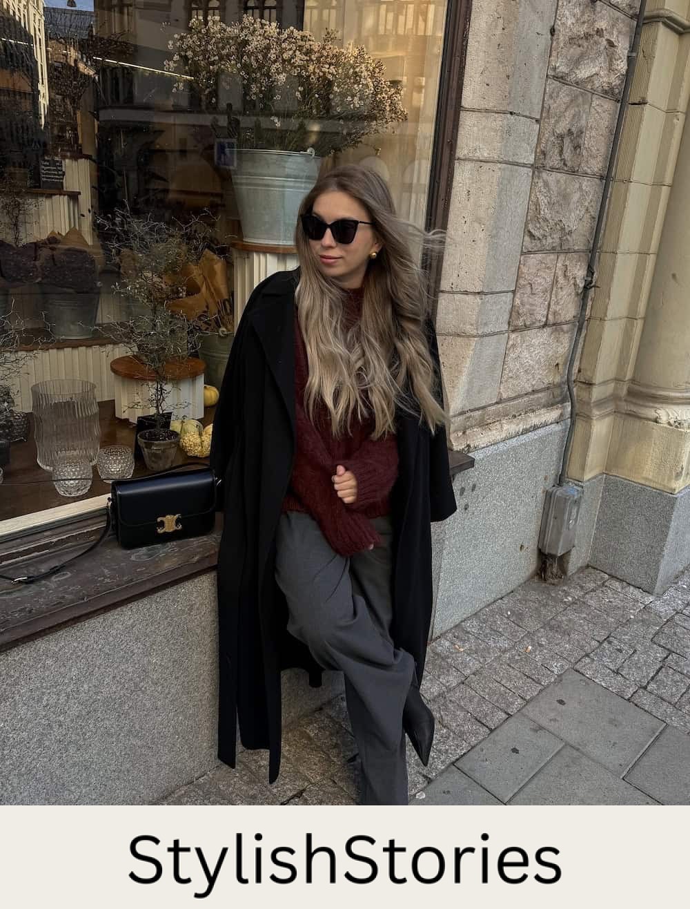 Woman wearing trousers with an oversized sweater and a trench coat.