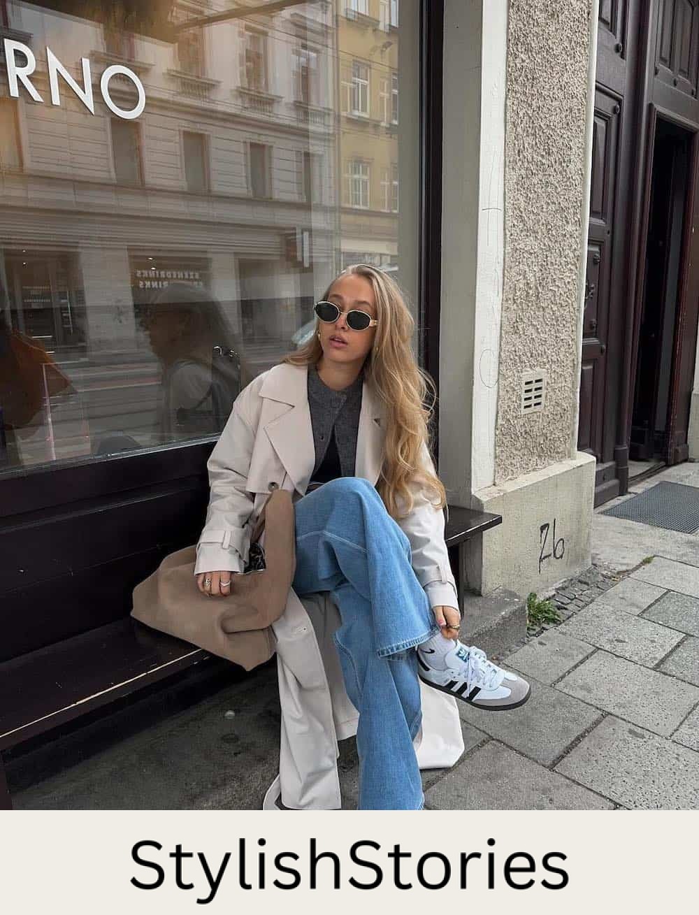 Woman wearing jeans with sneakers and a cardigan.