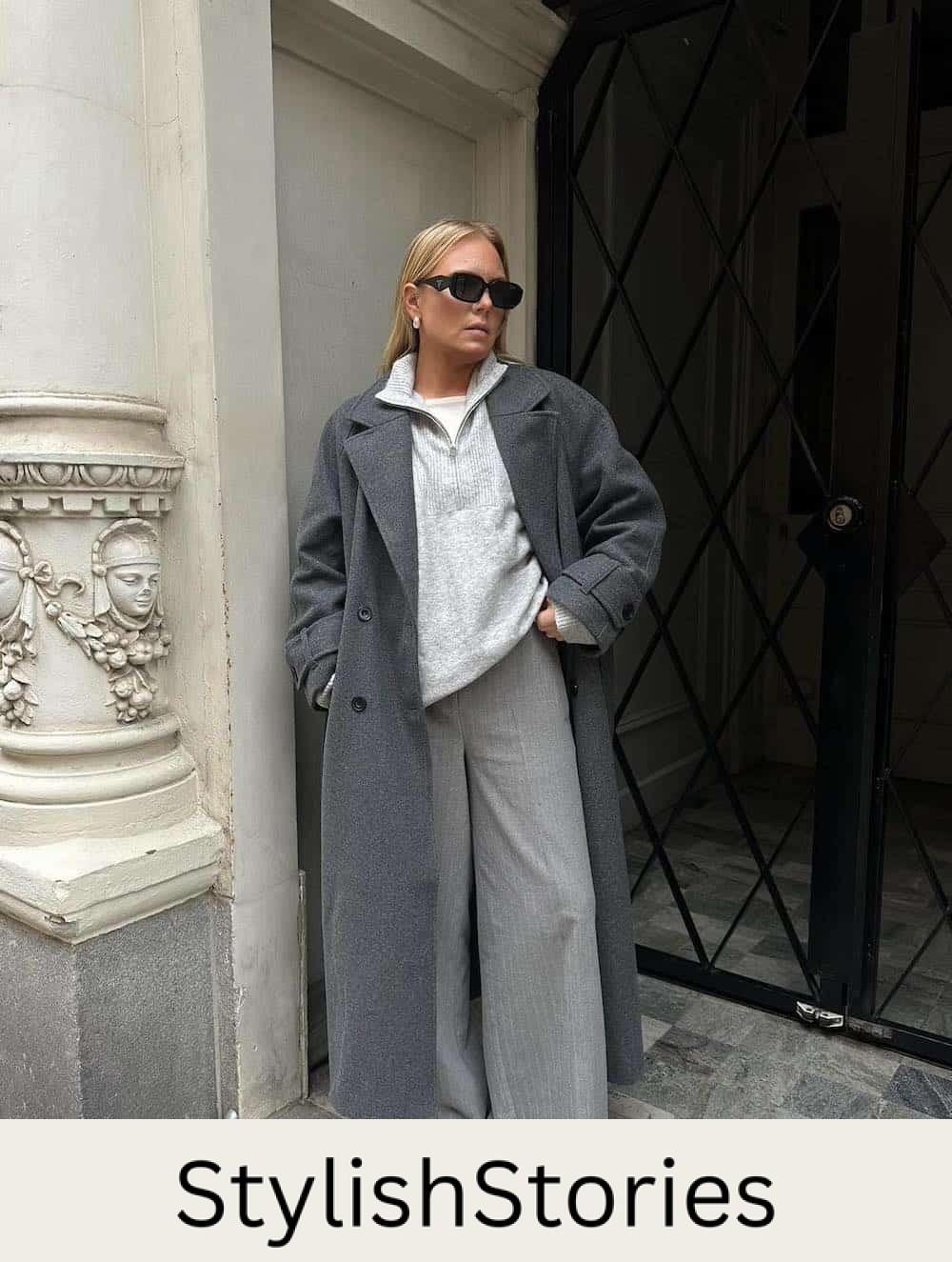 Woman wearing baggy trousers with an oversized sweater and a long wool coat.