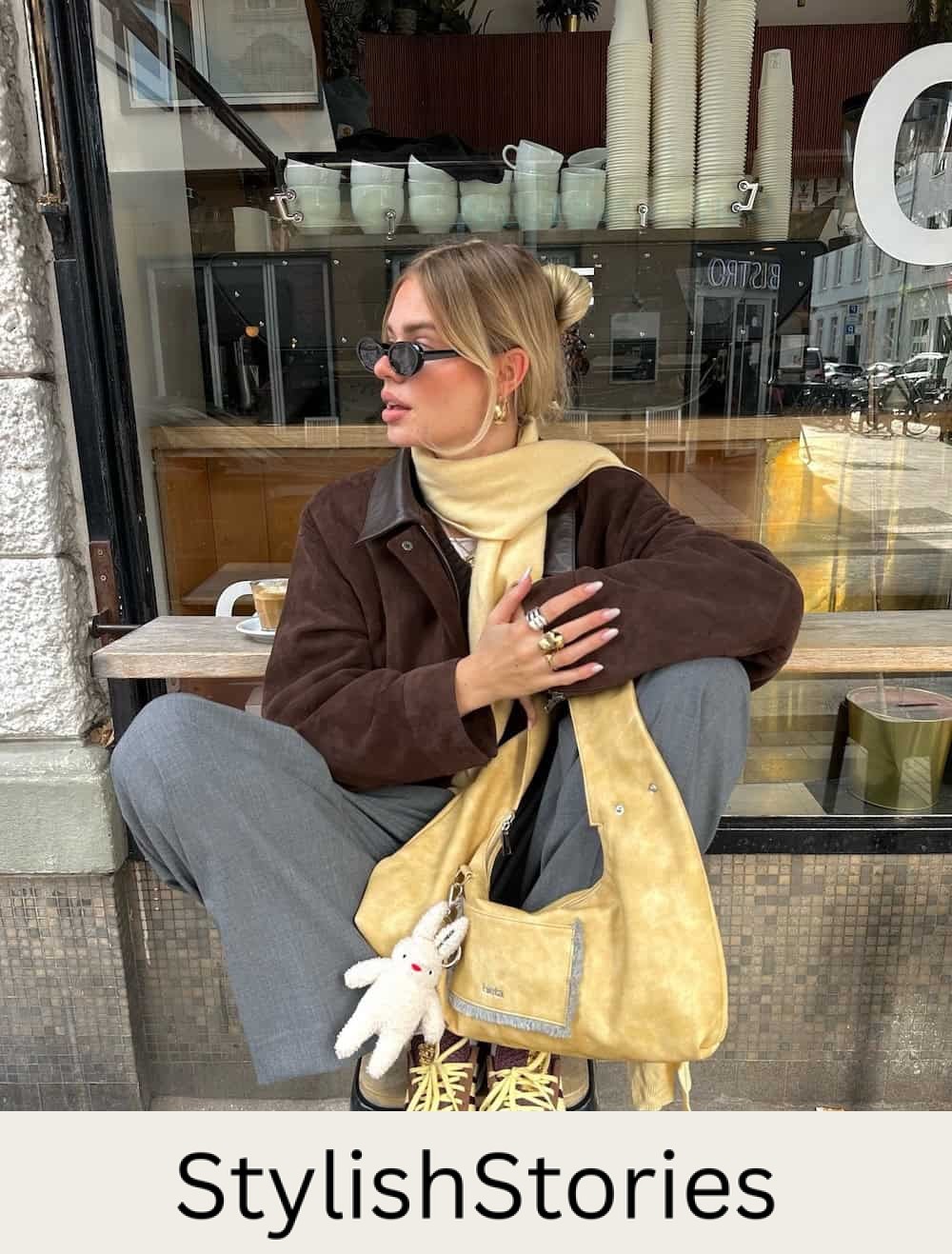 Woman wearing trousers, sneakers and a suede jacket.
