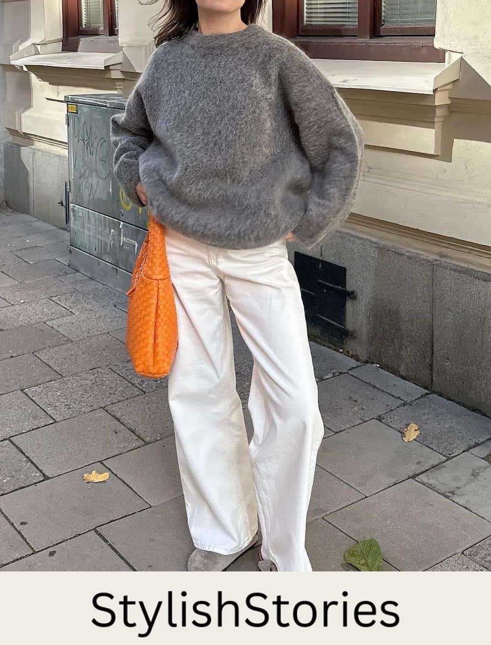 Woman wearing white jeans, Birkenstocks and an eyelash sweater.